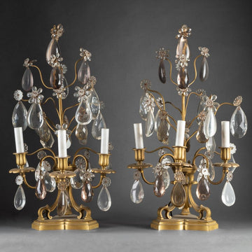 A PAIR OF FRENCH TURN OF THE CENTURY LOUIS XVI ST. CRYSTAL AND BRASS GIRANDOLES IN THE MANNER OF BAGUES.